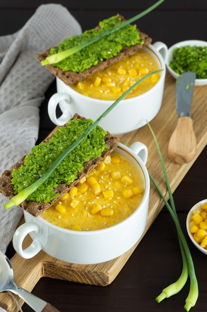 Sopa de maíz con paté de ajo fresco en un tazón Comida saludable sobre fondo de madera negra Cocina vegana