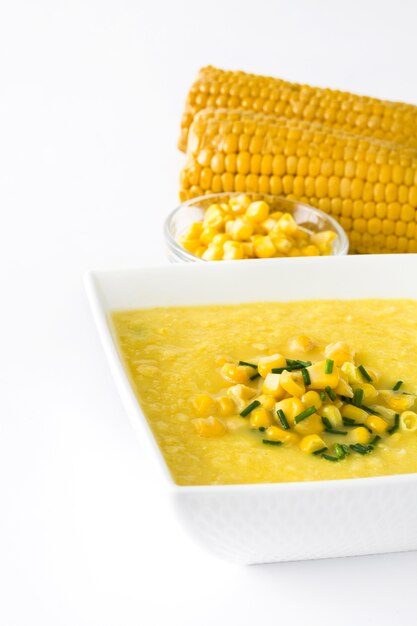 Sopa de maíz en un tazón blanco aislado en la superficie blanca