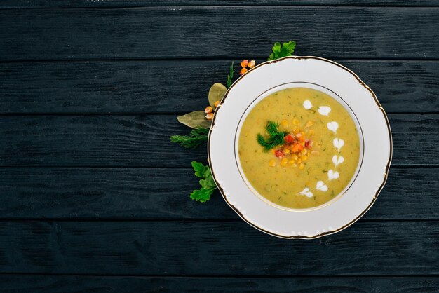 Foto sopa de maíz con verduras frescas en un bol comida sana sobre un fondo de madera negra vista superior copiar espacio para el texto