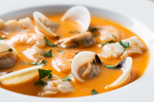 Foto sopa de mariscos sobre mesa de madera