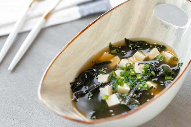 Sopa de miso japonesa en un recipiente blanco sobre la mesa