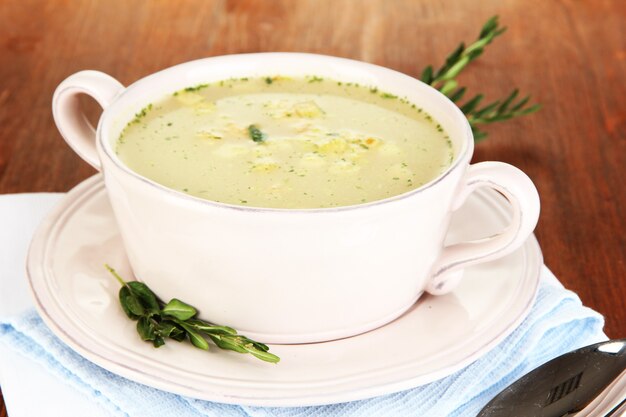 Sopa nutritiva em panela rosa em close-up de mesa de madeira