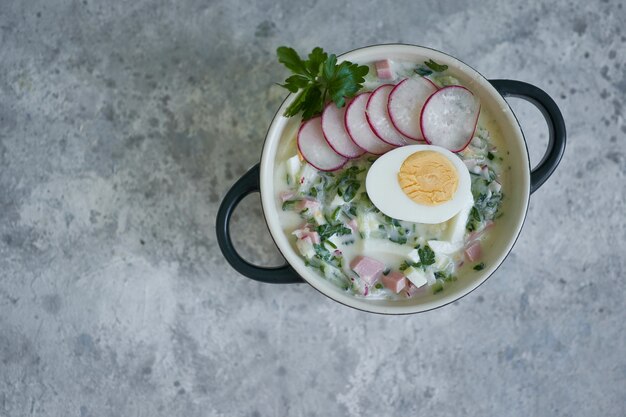 Sopa okroshka fría tradicional rusa servida en un plato con hierbas y huevo Kéfir sopa de verduras