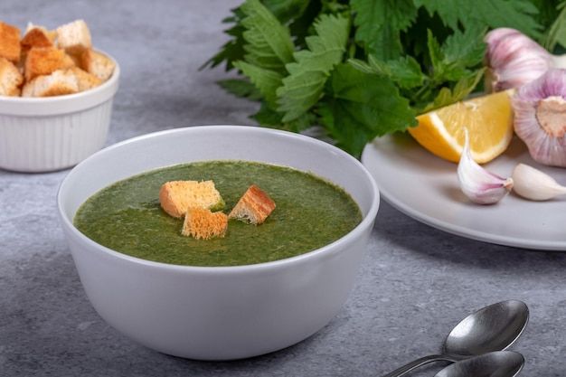 Sopa de ortiga y ajos silvestres cebolla limón y galletas saladas Comida vegana saludable