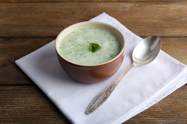 Sopa de pepino en un tazón sobre fondo de mesa de madera rústica