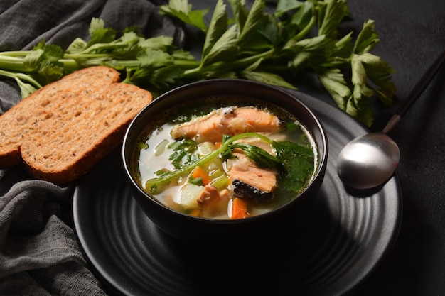 Sopa de pescado fresco sobre fondo negro Sopa de salmón