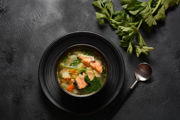 Sopa de pescado fresco sobre fondo negro Sopa de salmón