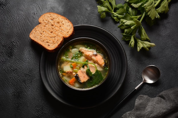 Sopa de pescado fresco sobre fondo negro Sopa de salmón