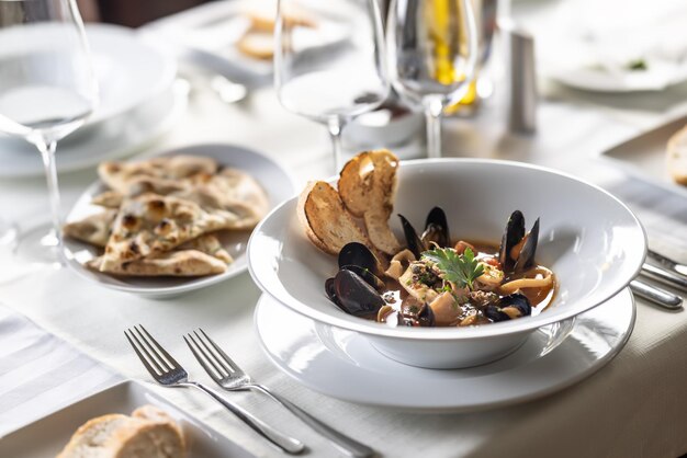 Sopa de pescado con marisco servida de forma estética en un plato en un restaurante