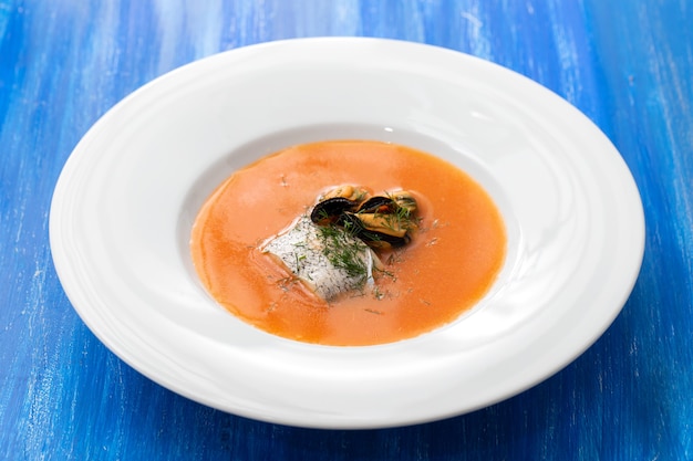 Sopa de pescado en plato blanco