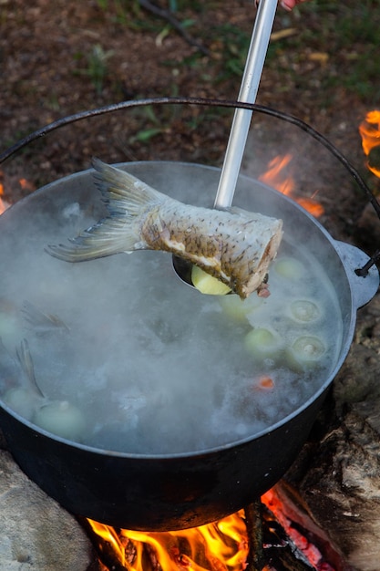 Sopa de pescado preparada a fuego abierto