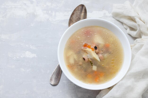 Sopa de pescado en un tazón blanco sobre cerámica