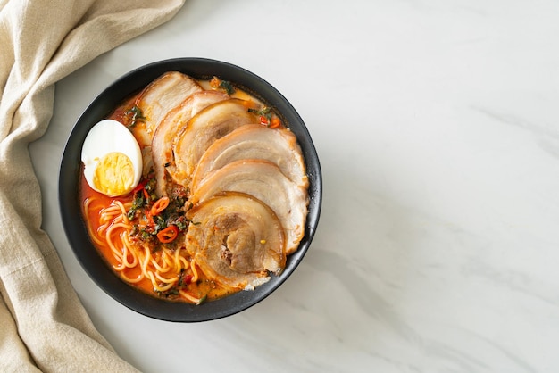 Sopa picante de fideos ramen tomyum con cerdo asado - estilo de comida fusión