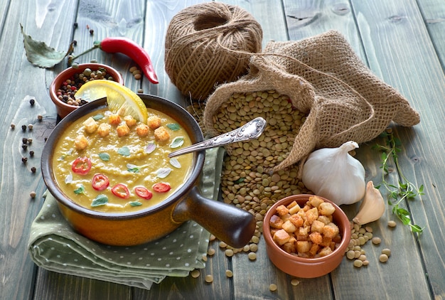 Sopa picante de lentejas con chile ajo y cebolla en mesa de madera