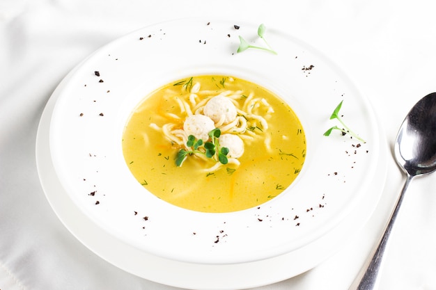 Sopa De Pollo Con Albóndigas Y Tallarines En Mesa Blanca