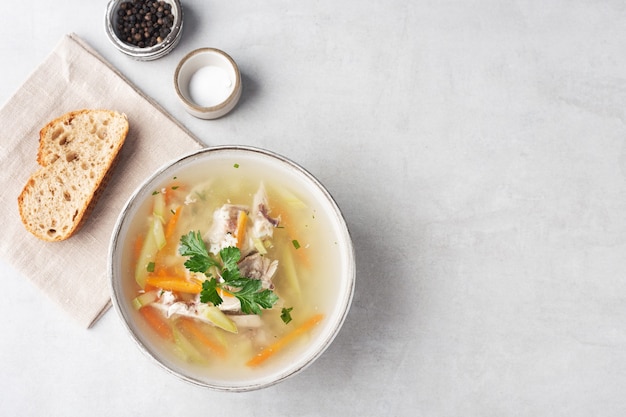 sopa de pollo en un bol con un trozo de pan