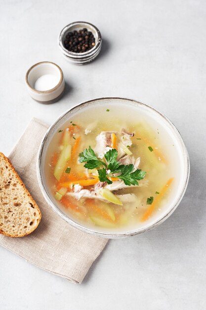 sopa de pollo en un bol con un trozo de pan