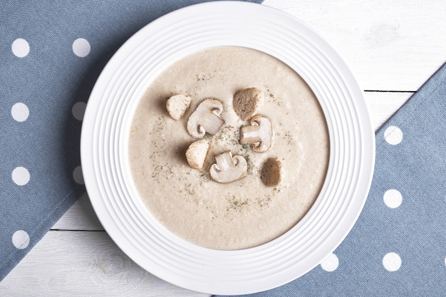 Sopa de pollo cremosa con champiñones en un plato blanco.