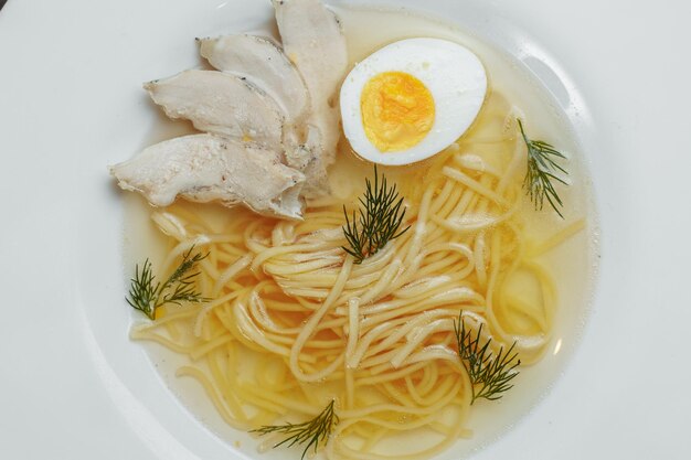 Sopa de pollo con fideos y verduras en tazón blanco