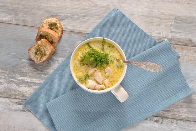 Foto sopa de pollo. sopa caliente de invierno con pollo y papas. sopa de sopa con pollo y papas. sopa cremosa fresca con pollo y verduras en un tazón blanco sobre el fondo de madera. comida sana