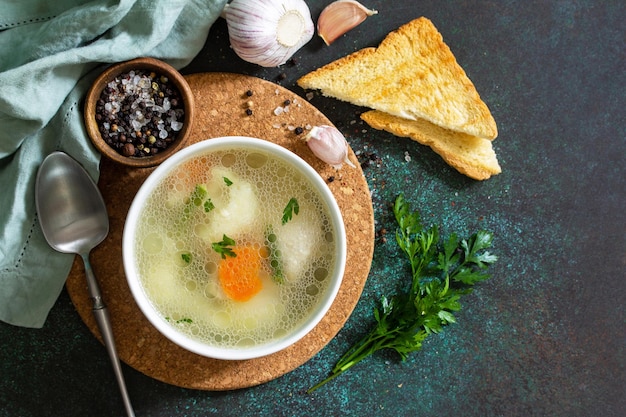 Sopa de pollo con verduras en una mesa de piedra oscura Vista superior de fondo plano laico