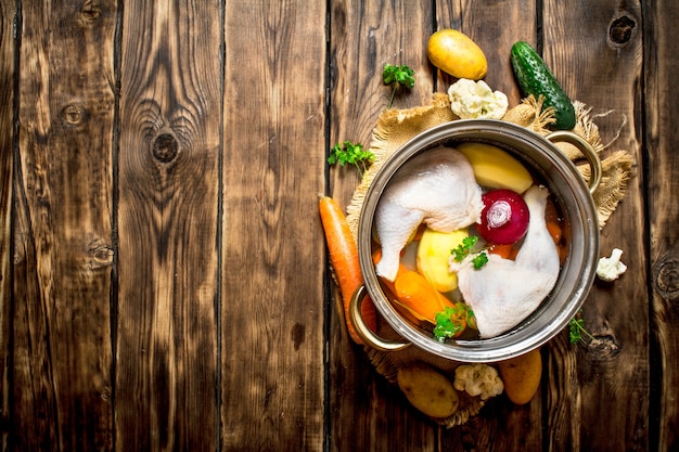 Sopa de pollo con verduras en una olla grande.