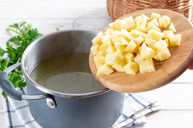 Sopa de preparación paso a paso con calabaza y verduras, paso - agregando papas picadas al caldo