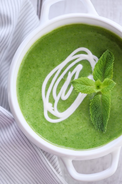 Sopa de puré de espinacas sazonada con crema y menta