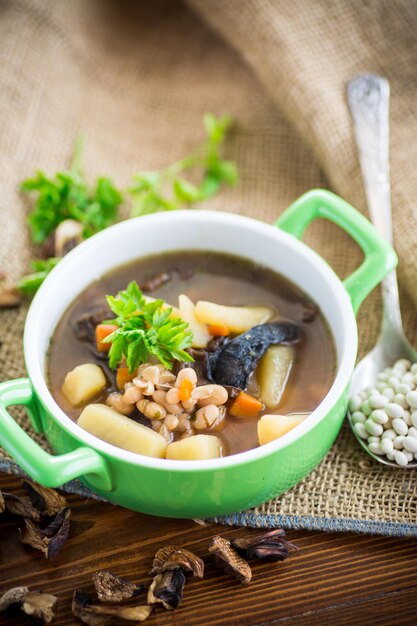 sopa quente de cogumelos com feijão em uma tigela sobre uma toalha de mesa rústica