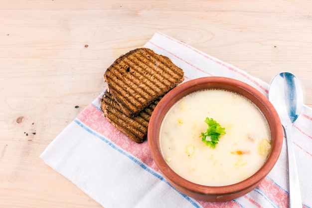 Sopa De Queso En Un Plato De Arcilla Con Pan Tostado