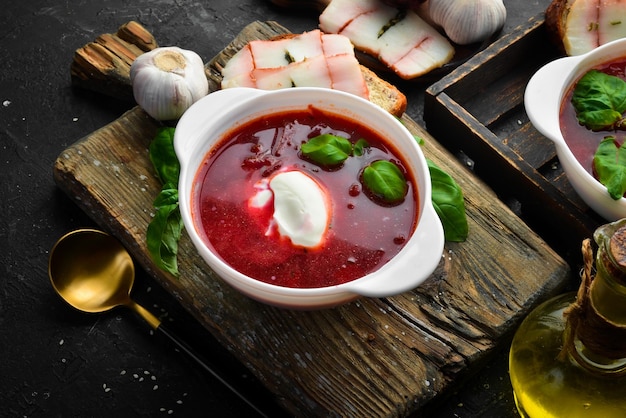 Sopa de remolacha Borsch ucraniano tradicional con crema agria y un sándwich de pan negro con manteca de cerdo Vista superior