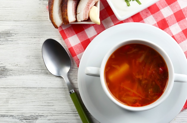 Foto sopa de remolacha ucraniana - borscht, en una servilleta, en una pared de madera