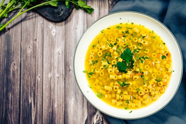 Sopa requintada de frango e vegetais com macarrãozinho e salsa feitos em casa. Vista superior copie o espaço