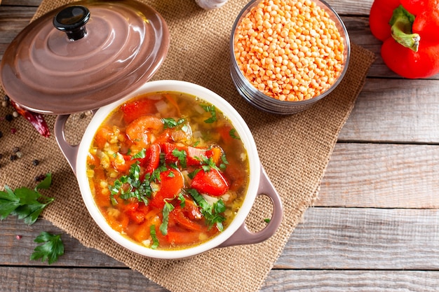 Sopa roja con lentejas y verduras sobre una mesa. Comida sana, comida sana. Vista superior con espacio de copia.