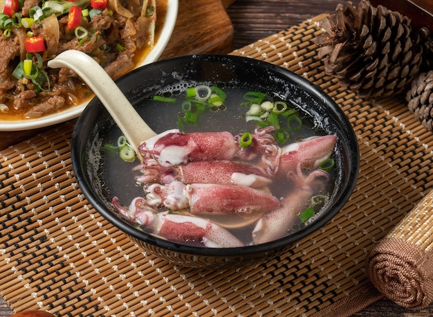 Sopa de rollo pequeño en un plato aislado en la vista lateral de la alfombra en la mesa de madera oscura comida de taiwán