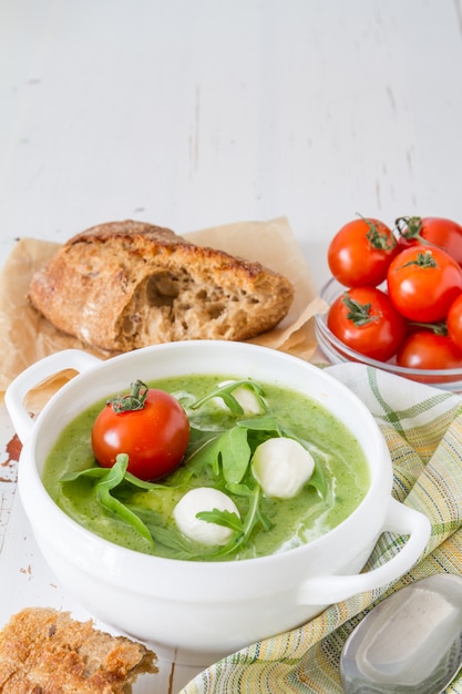 Sopa de rúcula y puré de tomates en un tazón blanco