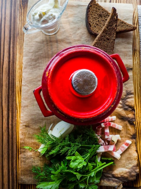 Sopa rusa en una cazuela de barro entre verduras hierbas y especias