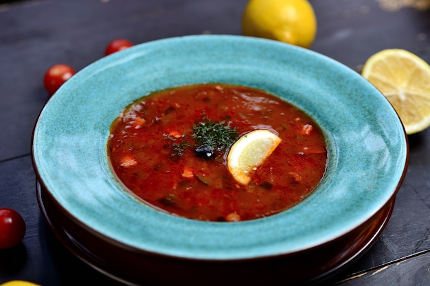 Sopa russa tradicional solyanka com carne, salsichas, legumes, alcaparras, picles e azeitonas com limão, temperos e especiarias