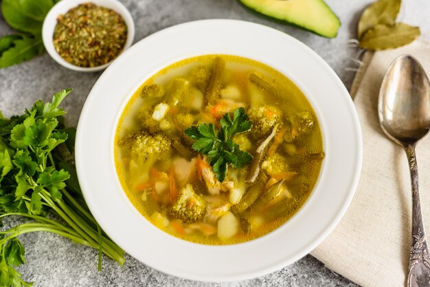 Foto sopa sabrosa de los vehículos y de las especias en un fondo concreto gris