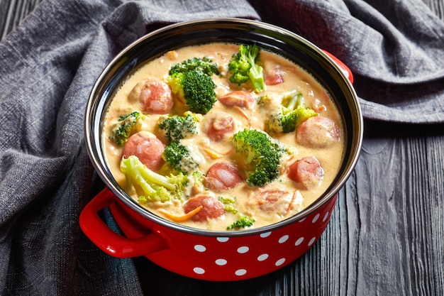 Sopa de salchicha con queso cheddar y brócoli en una olla