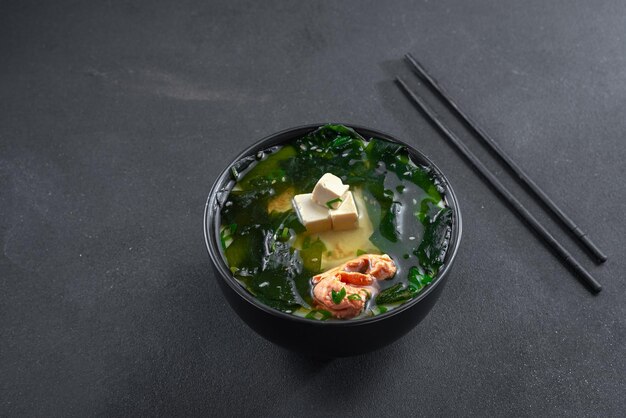 Sopa de salmón asiático en la vista superior de fondo negro