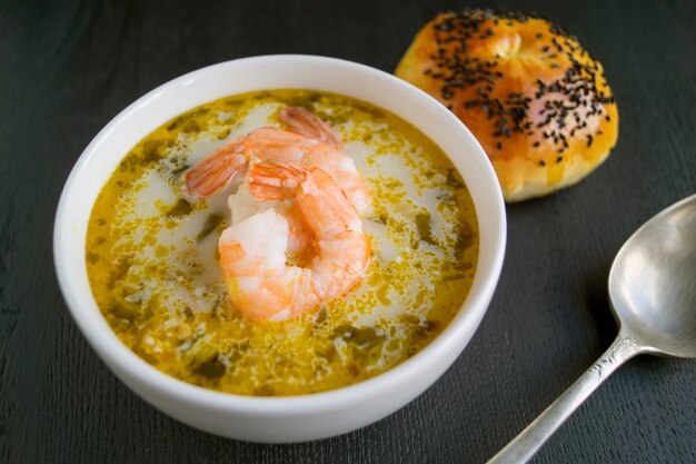 Sopa De Salmón Con Crema, Patatas, Zanahorias Y Eneldo. sobre un fondo negro.