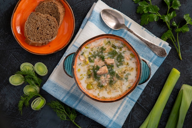 Sopa de salmón finlandesa con puerro y crema Comida sana rica en vitaminas, antioxidantes y fibra Vista superior sobre una mesa oscura