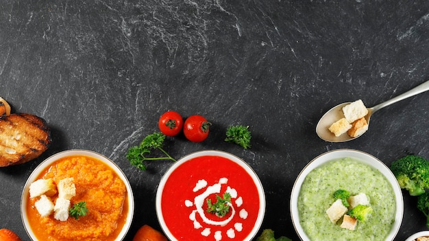 Sopa saludable de verduras de tres tazones con espacio de copia en la mesa de pizarra negra