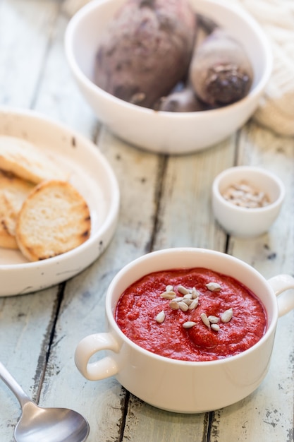 Sopa saudável de tomate em uma tigela branca com creme e sementes de sunflover