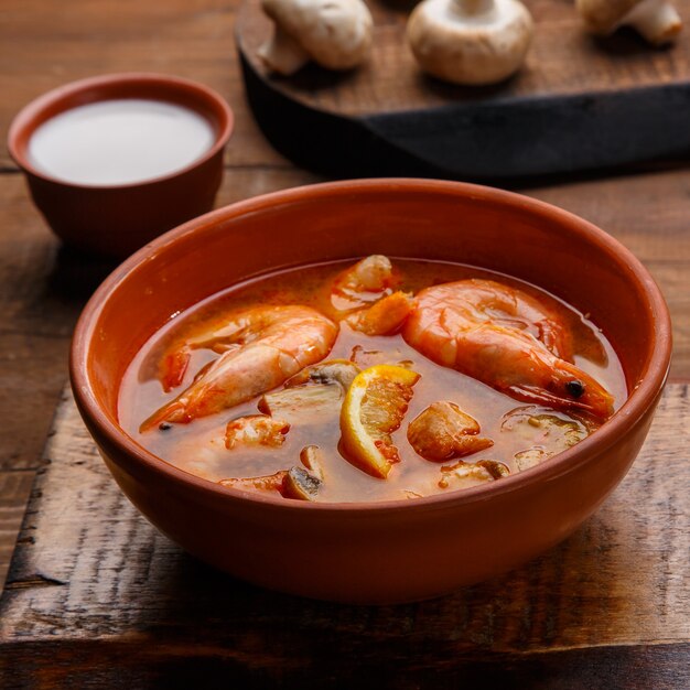 Sopa de tom yam con camarones y leche de coco en un plato Foto cuadrada