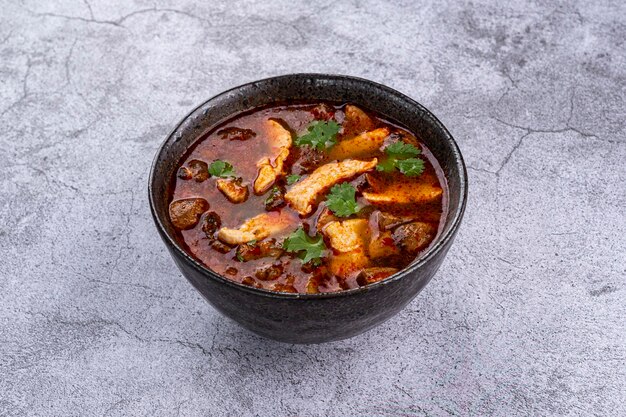 Foto sopa de tom yum con camarón sobre un fondo gris