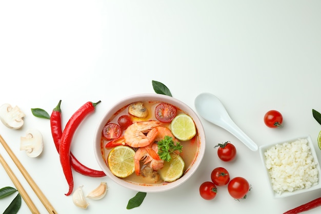 Sopa tom yum e ingredientes em fundo branco