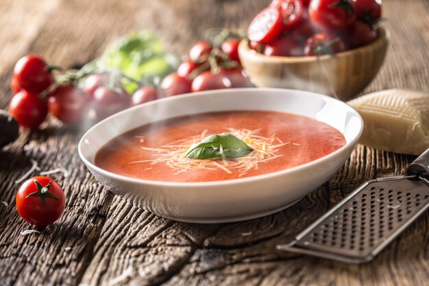 Sopa de tomate caliente, queso parmesano y albahaca dejar en la vieja mesa oal.