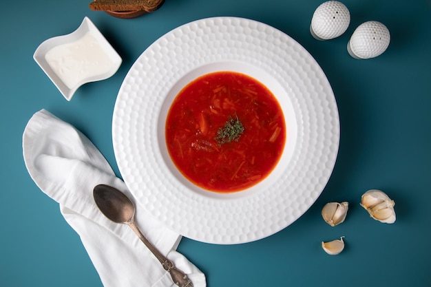 Sopa de tomate y carne sobre un fondo azul Bolas de carne de frijol de tomate picante en una cuchara de madera